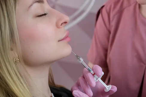 Косметолог вводит филлер в подбородок